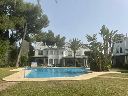 a large house with a swimming pool in front of it at Spacious house with private pool next to Golf Club in Marbella