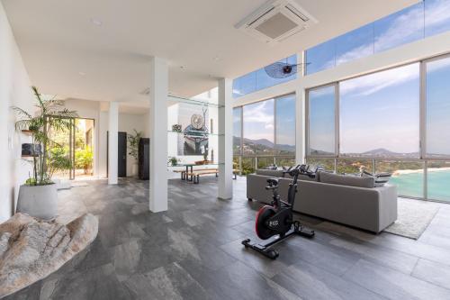 a living room with a couch and a gym at Villa Anushka - Modern luxury villa with picture-perfect sea views in Koh Samui