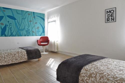 um quarto com uma cama e uma cadeira vermelha em La Piccola Casa di Via Ricotti em Castelguglielmo