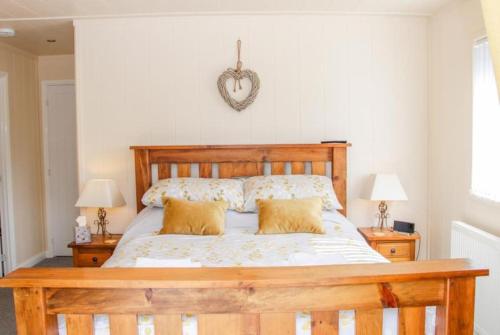 a bedroom with a wooden bed with two lamps at Fabulous detached lodge with hot tub two nights minimum stay in Bridgnorth