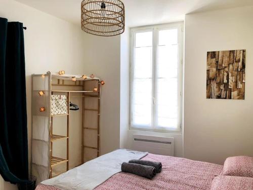 1 dormitorio con cama y ventana en Joli T2 en centre-ville de Rochefort, en Rochefort