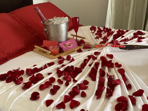 a cake with red rose petals on a bed at Pousada Lótus in Chapada dos Guimarães