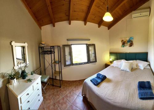 a bedroom with a large bed with blue towels on it at Villa Rosemari, Anatoli Apartment in Afráta