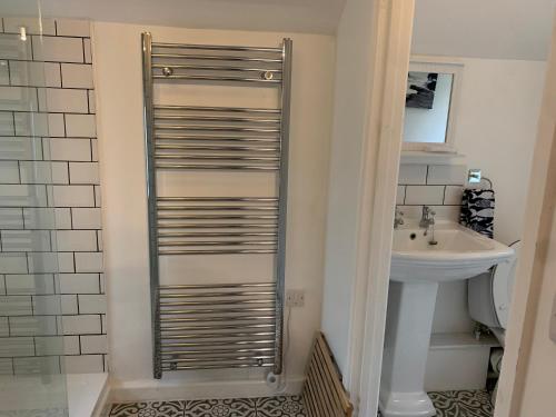 a bathroom with a toilet and a sink at 1 bed-cottage-Parking-Patio-close to coasts in North Hill