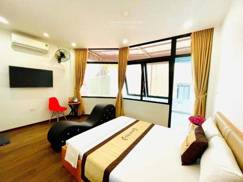 Habitación de hotel con cama y silla roja en A&EM VILLA - 133 Tam Khương - by Bay Luxury, en Hanói