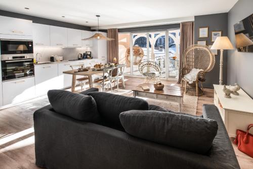 a living room with a couch and a kitchen at Résidences Alticimes in Brides-les-Bains