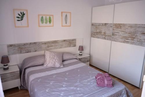 a bedroom with a bed with a pink bag on it at Apartamento “Las Calmas” en Huesca in Huesca