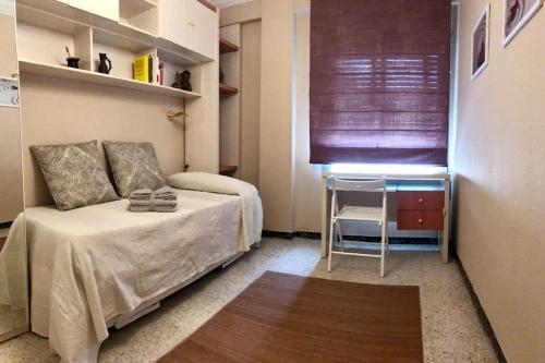 a small bedroom with a bed and a table at Apartamento “Las Calmas” en Huesca in Huesca