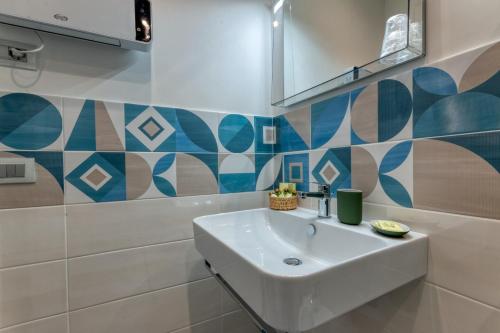 a bathroom with a white sink and blue and white tiles at La Dimora di Nonna Maria in Maiori
