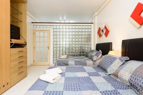 um quarto com 2 camas, uma televisão e uma cómoda em Ipanema avenida Vieira Souto no Rio de Janeiro