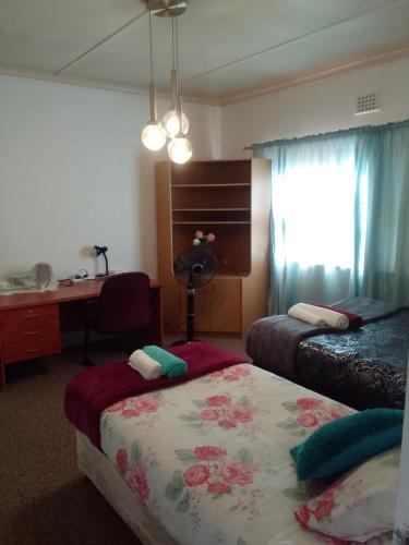 a hotel room with two beds and a desk at LRN Brackenfell Homestay in Cape Town