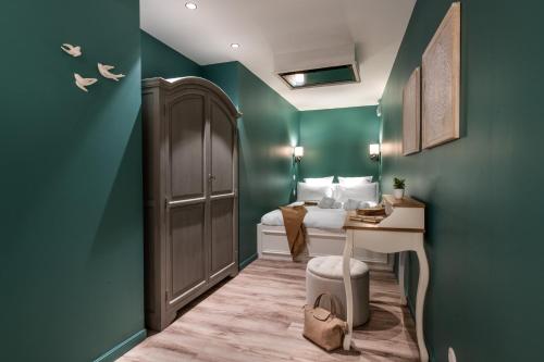 a bedroom with green walls and a bed and a desk at Résidences Alticimes in Brides-les-Bains