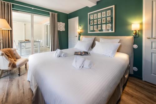 a bedroom with a large white bed with towels on it at Résidences Alticimes in Brides-les-Bains