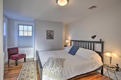 1 dormitorio con 1 cama, 1 silla y 1 ventana en Bright Apartment - half Mi to Greenport Harbor!, en Greenport