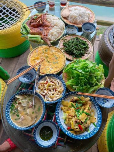 a table with many plates of food on it at Phong Nha Memory Homestay in Phong Nha