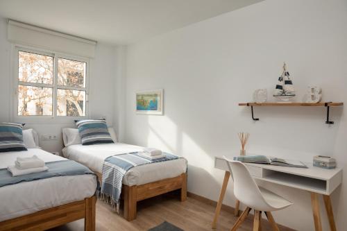 um pequeno quarto com 2 camas e uma secretária em Flateli Platja d'Aro Port 2 em Platja d'Aro