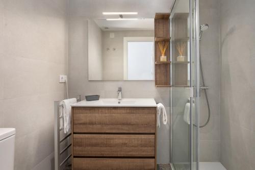 uma casa de banho com um lavatório e um chuveiro em Flateli Platja d'Aro Port 2 em Platja d'Aro