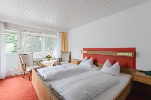 a bedroom with a large bed with a red headboard at Sauerländer Hof in Eslohe