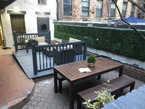 una mesa de madera y bancos en un patio en 26-2C Furnished 1BR Gramercy W D Courtyard, en Nueva York