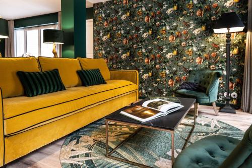 a living room with a yellow couch and a christmas tree at Résidences Alticimes in Brides-les-Bains