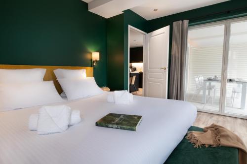 a bedroom with a large white bed with a book on it at Résidences Alticimes in Brides-les-Bains