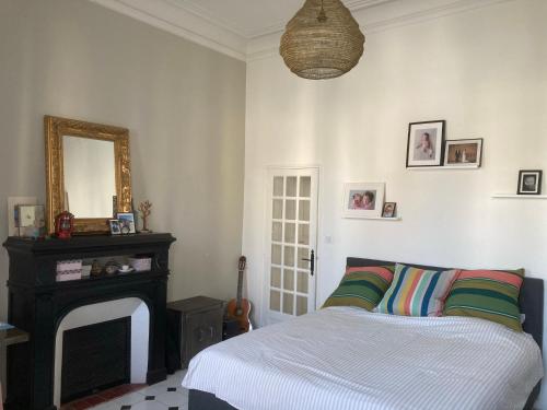 um quarto com uma cama e um espelho na parede em Charmante maison de ville à Salon de Provence em Salon-de-Provence