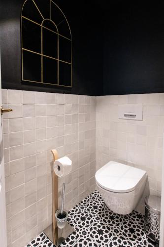 a bathroom with a white toilet and a black wall at Résidences Alticimes in Brides-les-Bains
