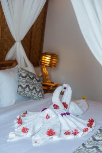 two swans wrapped in towels on a bed at Penida Sunset Ocean View Bungalows in Nusa Penida