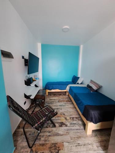 ピスコにあるPisco Bed and Sunsetのベッドルーム(青いベッド1台、椅子付)