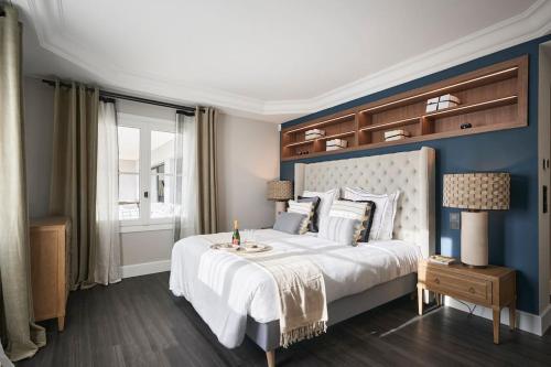 une chambre avec un grand lit avec un mur bleu dans l'établissement Cannes magnifique villa vue mer basse Californie, à Cannes