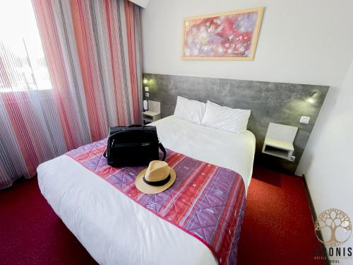 a hotel room with a bed with a hat on it at Adonis Gapotel in Gap