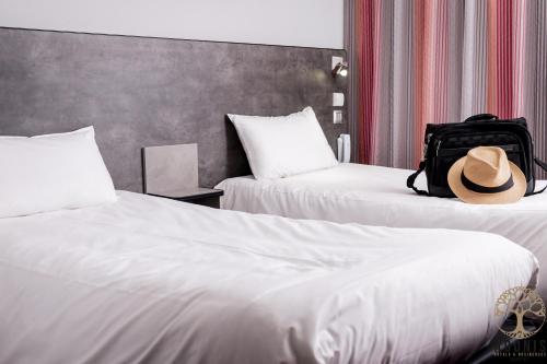 a hat sitting on top of two beds in a hotel room at Adonis Gapotel in Gap
