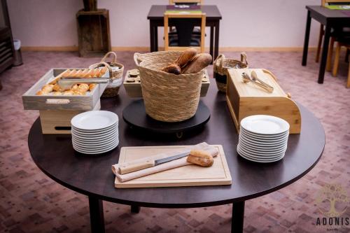 a table with bread and baskets and plates on it at Adonis Gapotel in Gap