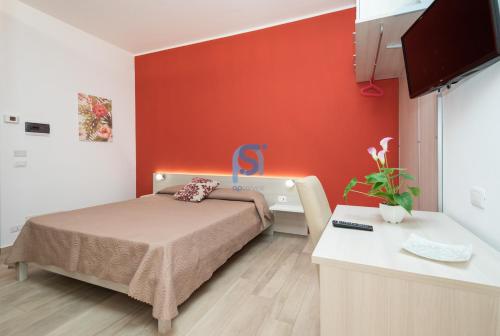 a bedroom with a bed and a red wall at B&B Panorama - Self Check in in Cefalù