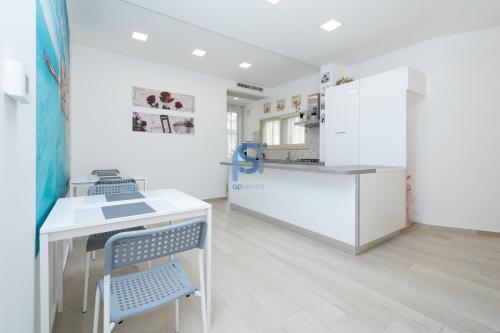 a kitchen with a table and chairs and a refrigerator at B&B Panorama - Self Check in in Cefalù