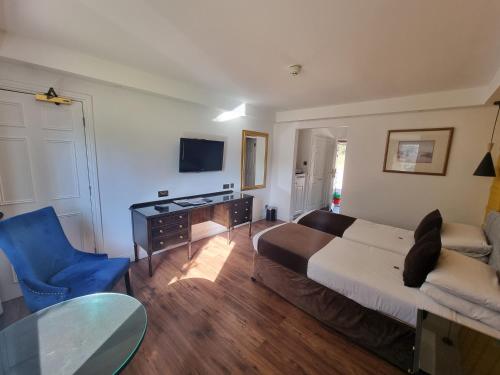 a living room with a bed and a blue chair at Muthu Belstead Brook Hotel in Ipswich