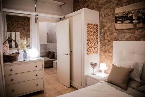 Apartament Imperial WI FI center Seville في إشبيلية: غرفة نوم بسرير وخزانة وغرفة
