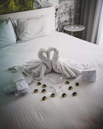 a white bed with a bunch of items on it at The G Hotel by JL in St Julian's