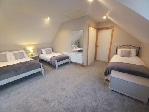 a attic room with two beds and a mirror at The Apartment in Langley Park