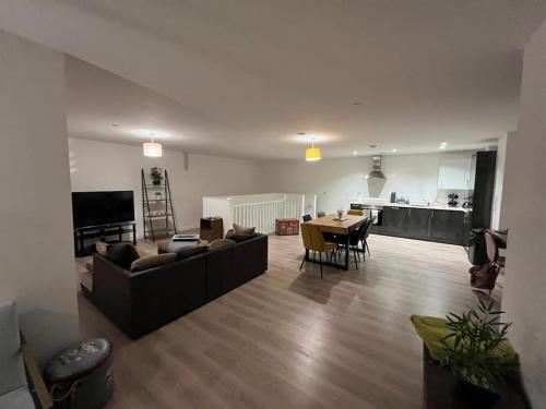 a living room with a couch and a table and a kitchen at Bayard Luxe 2 Bedroom Penthouse Duplex in Peterborough
