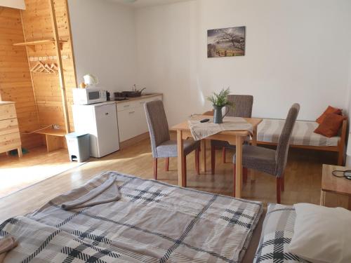 a living room with a table and chairs and a kitchen at Főnix Panzió in Eger