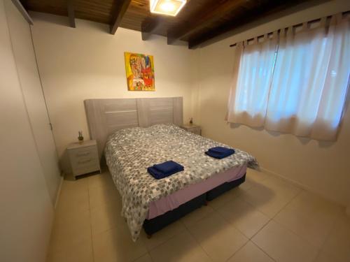 a bedroom with a bed with two blue towels on it at Hermoso Departamento mendoza capital in La Cieneguita