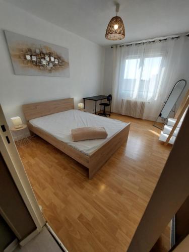 - une grande chambre avec un lit et du parquet dans l'établissement 3 chambres NETFLIX INCLUS, à Troyes