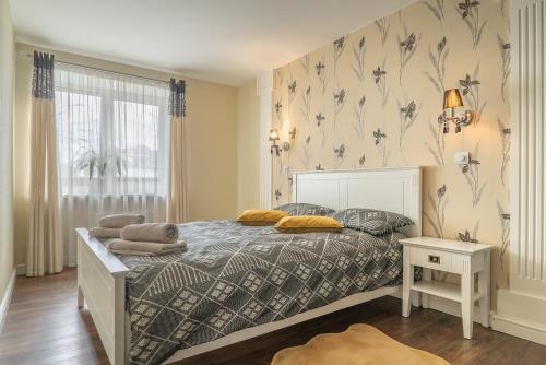 1 dormitorio con 1 cama con manta y ventana en Andrea Apartment, en Liepāja
