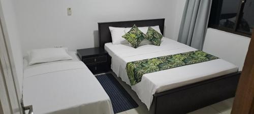 - 2 lits dans une petite chambre aux murs blancs dans l'établissement Otantik Residence, à Victoria