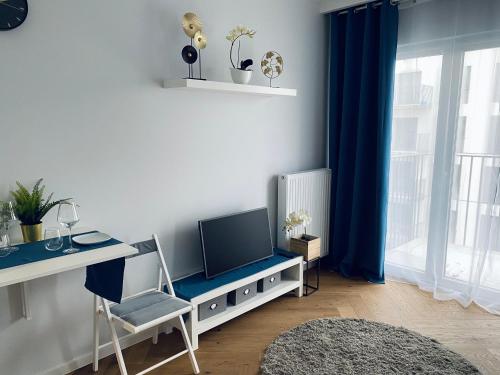 - un salon avec un bureau, une télévision et une chaise dans l'établissement Wileńska home apartment 2, à Varsovie