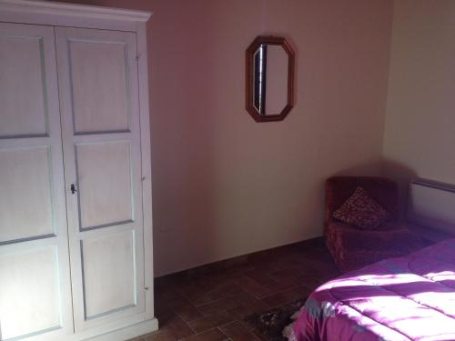 a bedroom with a door and a chair and a mirror at La Locanda Del Colle in Canalicchio