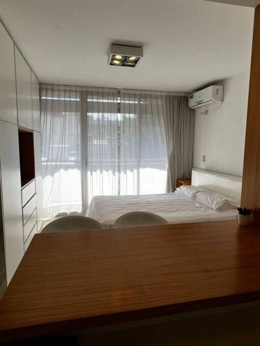 a bedroom with a bed and two chairs and a window at Mono frente al sanatorio de la mujer in Rosario
