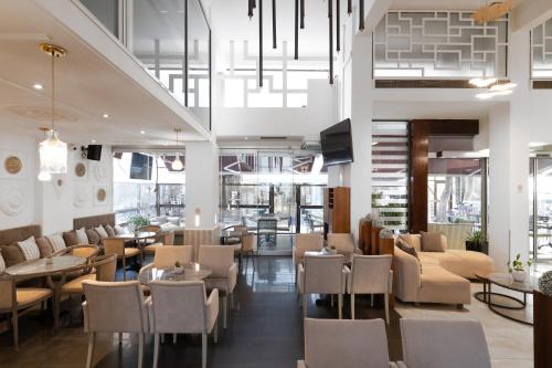 un restaurante con mesas y sillas y un vestíbulo en Hotel Ntinas en Tríkala