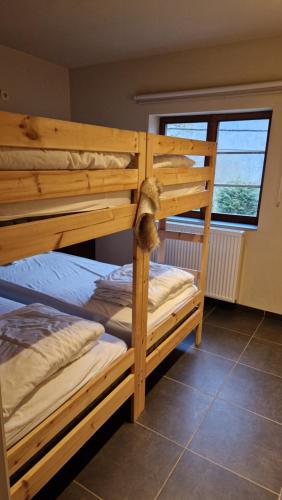 two bunk beds in a room with a window at Chalet Coo in Stavelot